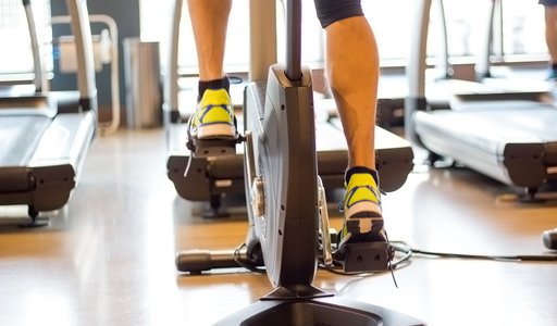 Athletic man cycling on stationary bike in gym